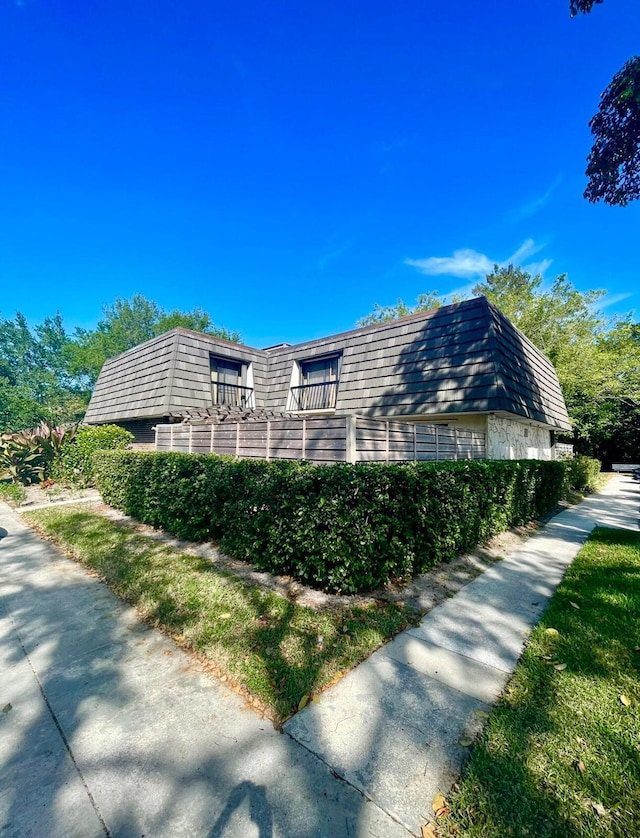 903 9th Ter, Palm Beach Gardens, FL 33418 - view of side of home with mansard roof and a balcony