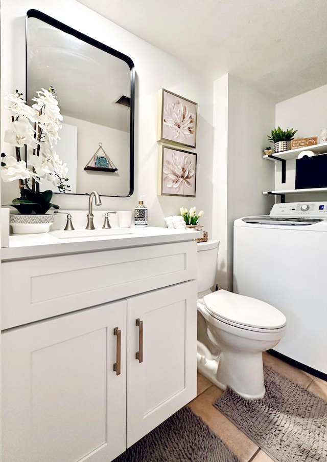 bathroom with washer / clothes dryer, tile patterned floors, vanity, and toilet