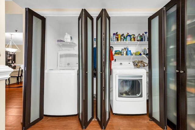 laundry room featuring wood-type flooring, washer / clothes dryer, and crown molding