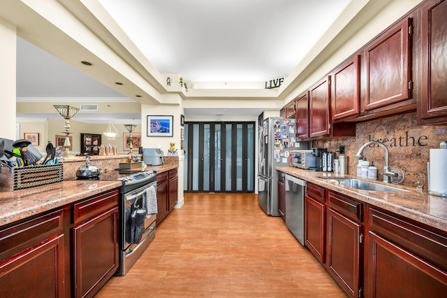 kitchen with tasteful backsplash, crown molding, a tray ceiling, sink, and appliances with stainless steel finishes