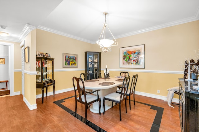 dining space with crown molding and hardwood / wood-style floors