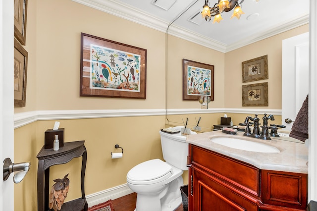 bathroom with crown molding, vanity, toilet, and an inviting chandelier