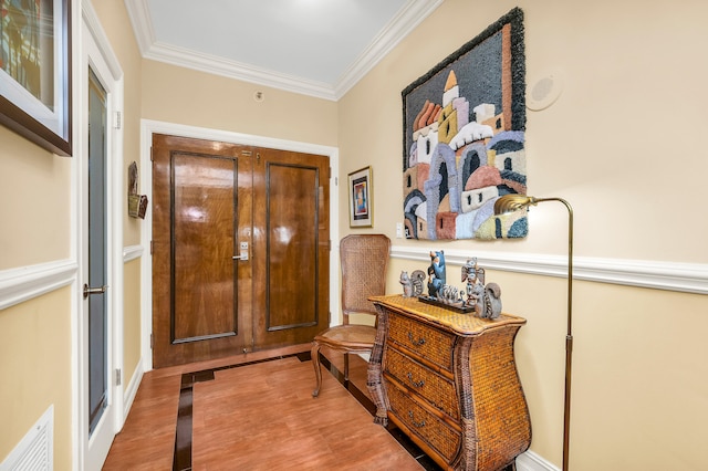 entrance foyer with ornamental molding and light wood-type flooring