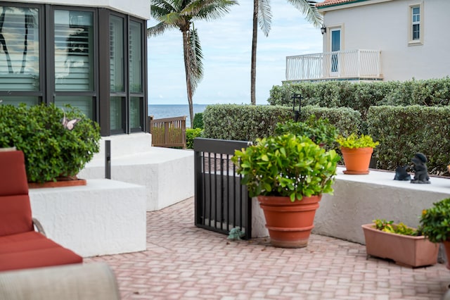 view of patio / terrace with a balcony and a water view