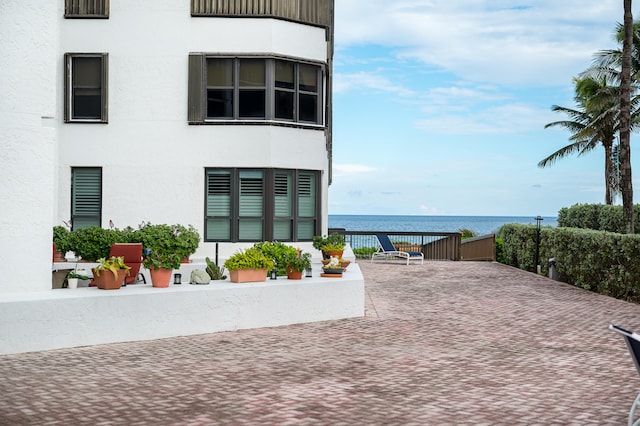 exterior space with a water view and a patio