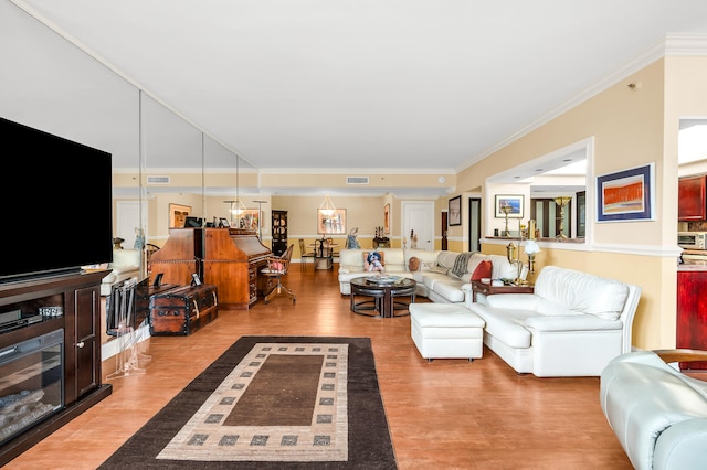 living room featuring light wood-type flooring and ornamental molding