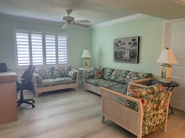 living room featuring a textured ceiling, light hardwood / wood-style flooring, and ornamental molding