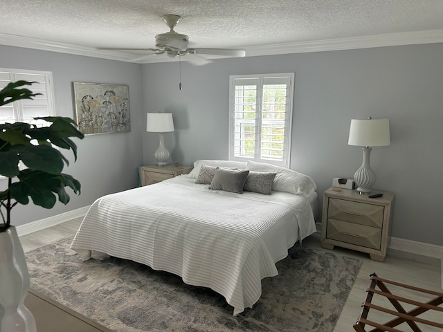 bedroom featuring ceiling fan, a textured ceiling, ornamental molding, and light wood-type flooring