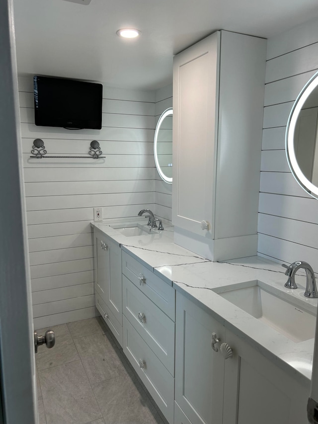 bathroom with wooden walls, tile patterned flooring, and vanity