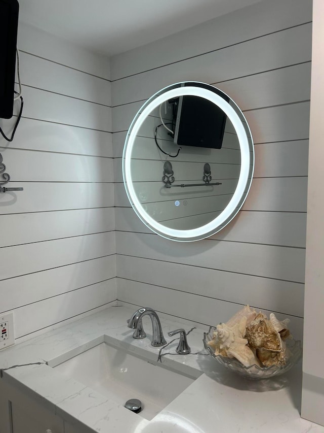 bathroom featuring vanity and wooden walls