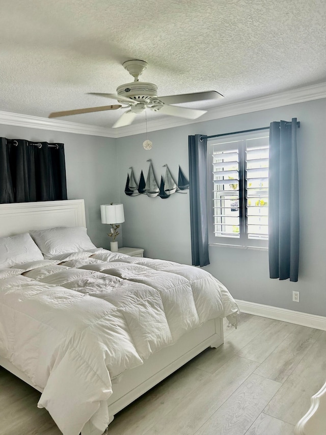 bedroom featuring ceiling fan, a textured ceiling, and crown molding