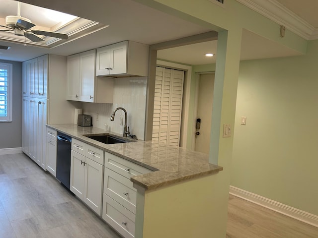 kitchen with black dishwasher, light hardwood / wood-style floors, light stone countertops, white cabinetry, and sink