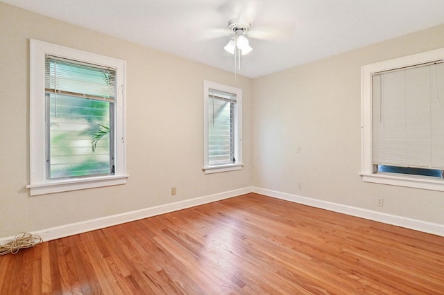 spare room with light hardwood / wood-style flooring, ceiling fan, and a healthy amount of sunlight