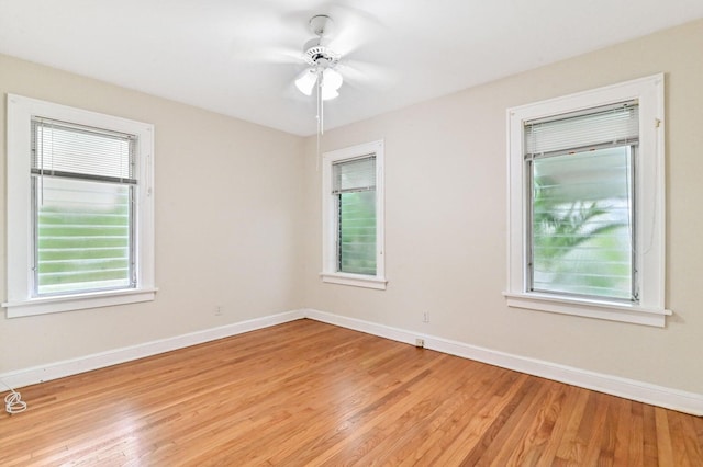 empty room featuring ceiling fan, plenty of natural light, and light hardwood / wood-style floors