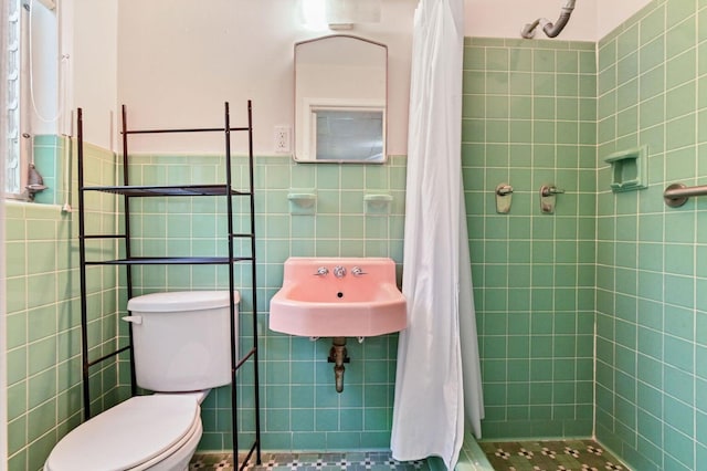 bathroom with walk in shower, sink, tile walls, and toilet