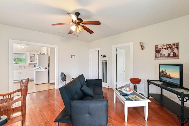 living room featuring hardwood / wood-style floors and ceiling fan