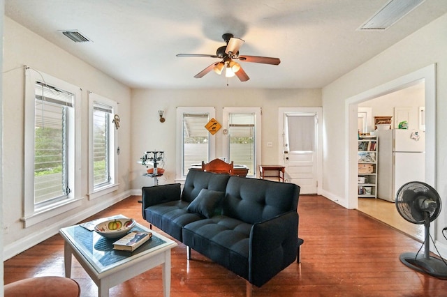 living room with ceiling fan and dark wood-type flooring