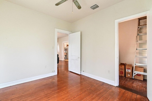 unfurnished bedroom featuring ceiling fan and dark wood-type flooring