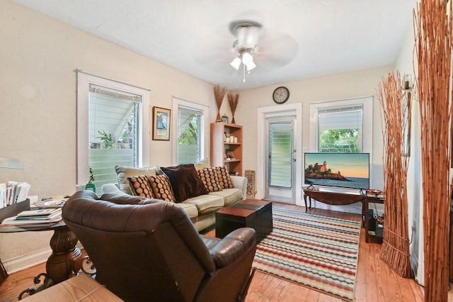 living room with ceiling fan, light wood-type flooring, and plenty of natural light