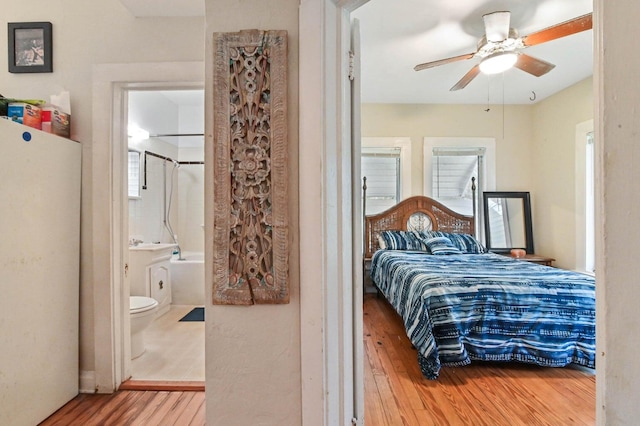 bedroom featuring ceiling fan, hardwood / wood-style flooring, and ensuite bath