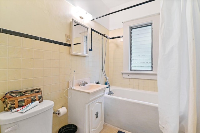 full bathroom with tile walls, vanity, toilet, and shower / bath combination with curtain