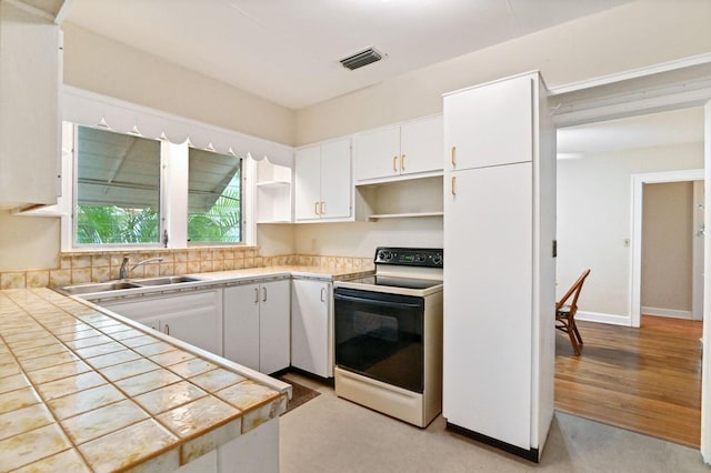 kitchen with white cabinets, white electric range oven, tile countertops, and light hardwood / wood-style floors