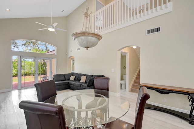 dining room featuring light wood-style flooring, visible vents, arched walkways, and french doors