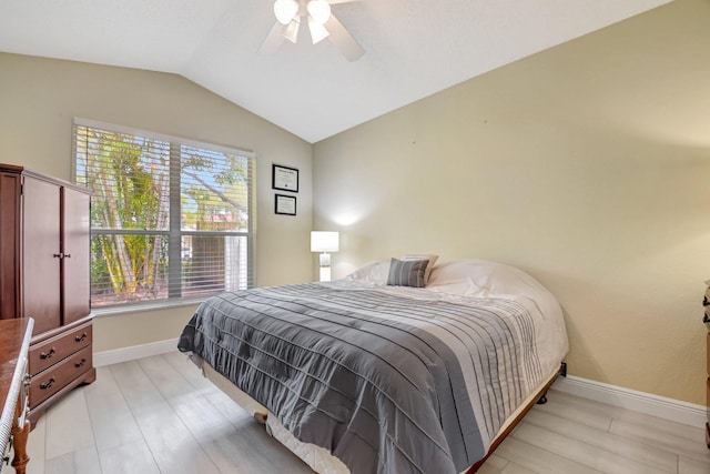 bedroom featuring lofted ceiling, light wood-style floors, baseboards, and a ceiling fan