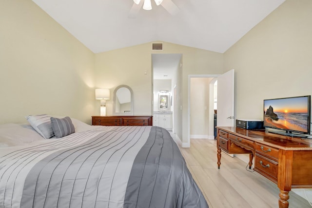 bedroom featuring light wood-style flooring, visible vents, a ceiling fan, vaulted ceiling, and ensuite bath