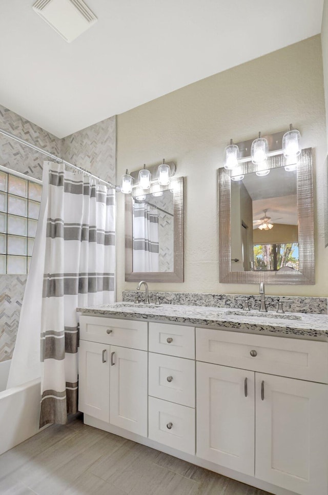 full bath featuring shower / bath combo with shower curtain, visible vents, a sink, and double vanity