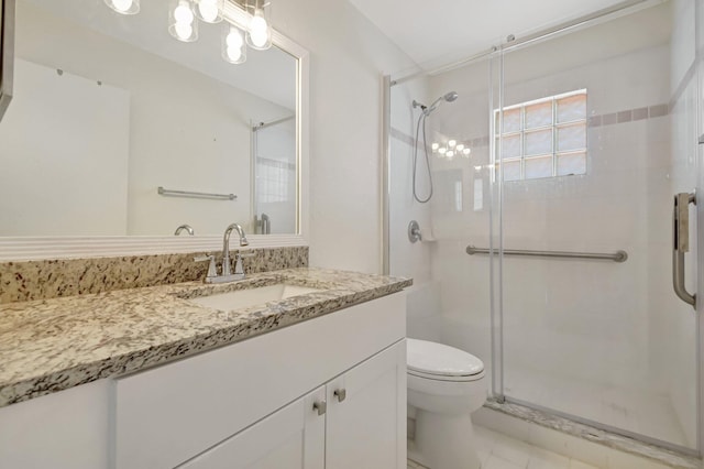 bathroom with toilet, a shower stall, and vanity