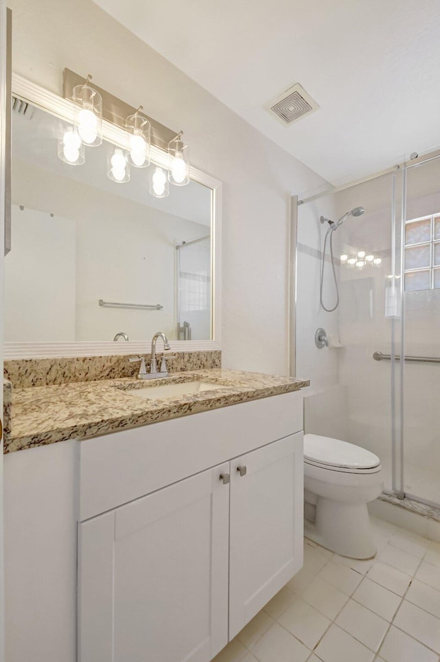 full bathroom featuring visible vents, toilet, a shower stall, vanity, and tile patterned floors