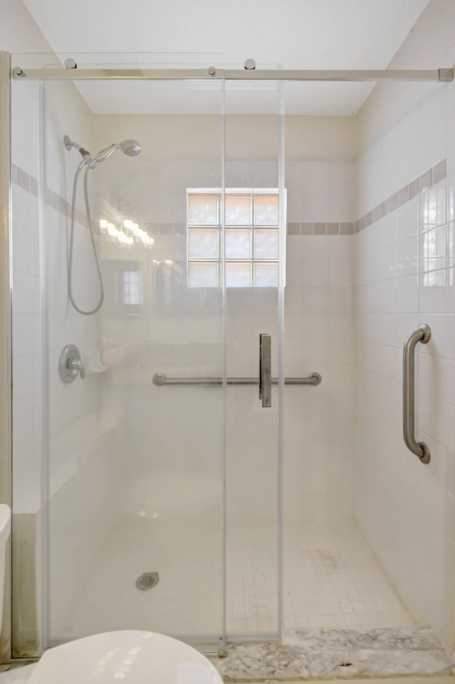 full bathroom featuring toilet and a stall shower