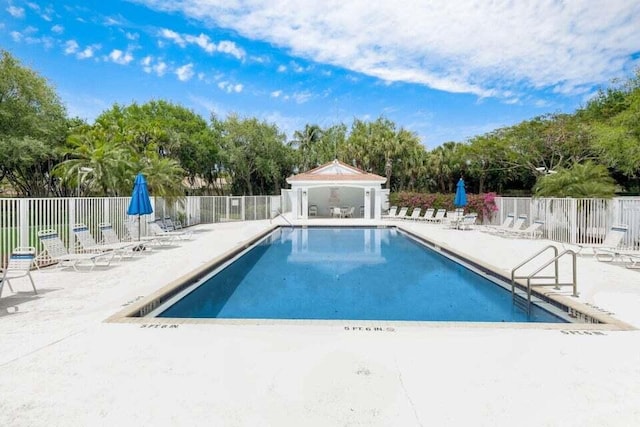 pool with a patio area and fence