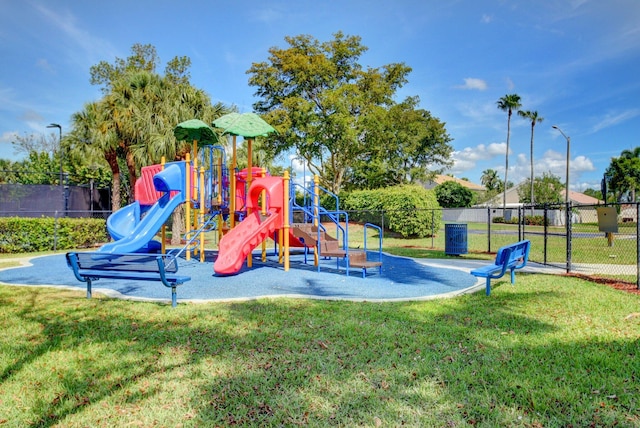 community playground featuring fence and a lawn