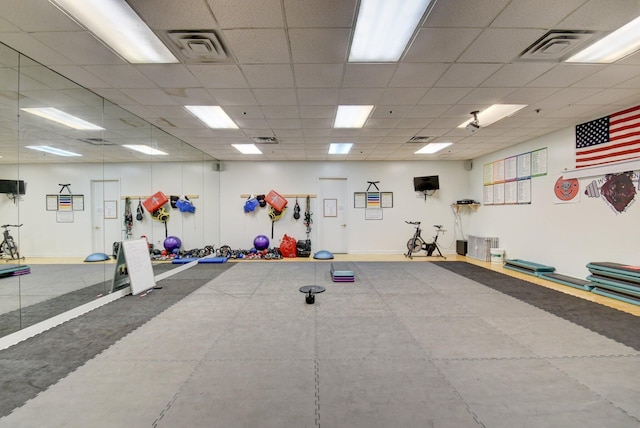 gym with baseboards, visible vents, and a drop ceiling