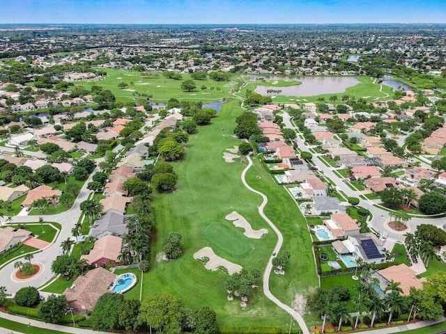 drone / aerial view featuring view of golf course, a water view, and a residential view