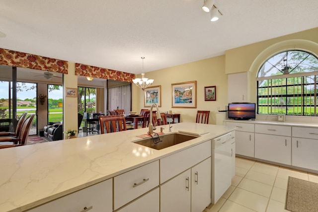 kitchen featuring decorative light fixtures, white dishwasher, a healthy amount of sunlight, and sink