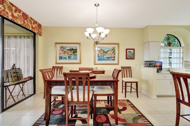 dining room featuring light tile patterned floors, a textured ceiling, and an inviting chandelier