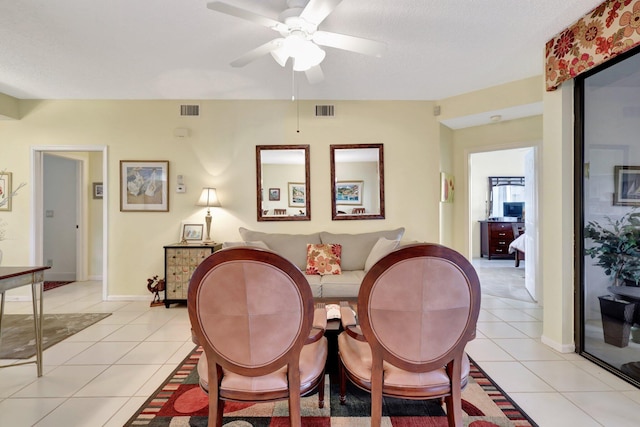 dining space with ceiling fan, light tile patterned flooring, and a textured ceiling