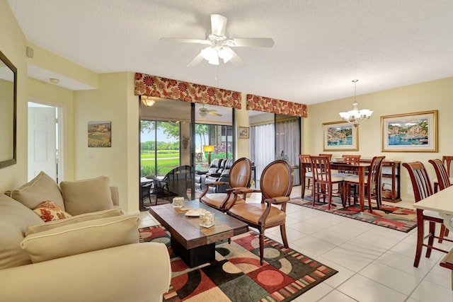 tiled living room with a textured ceiling and ceiling fan with notable chandelier