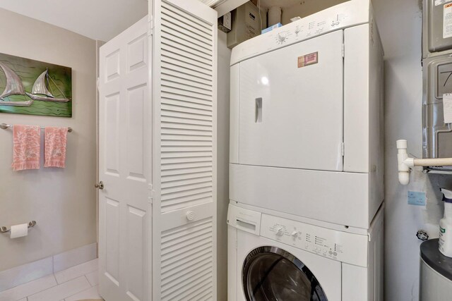 laundry room featuring light tile patterned floors and stacked washer and clothes dryer