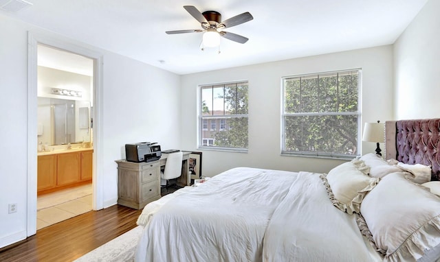 bedroom with ceiling fan, ensuite bathroom, and hardwood / wood-style floors