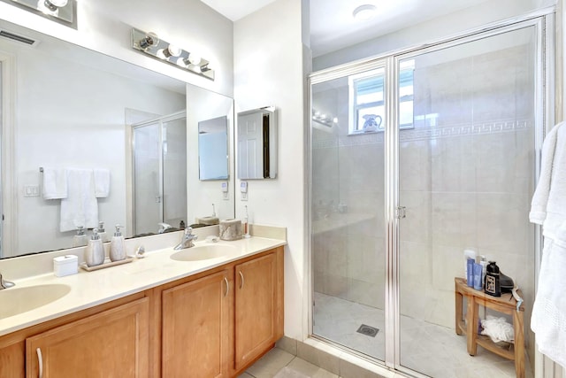 bathroom featuring tile patterned flooring, a shower with shower door, and vanity