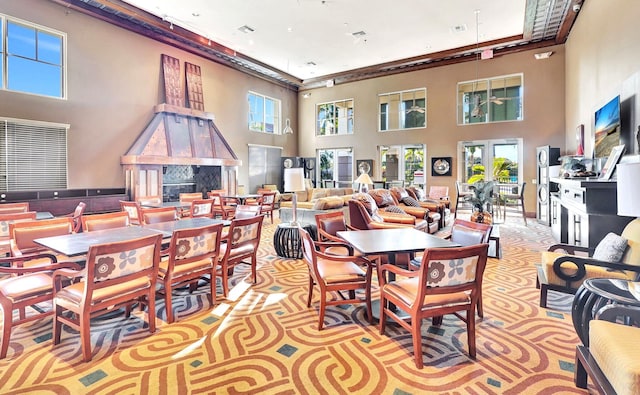 carpeted dining space with a high ceiling