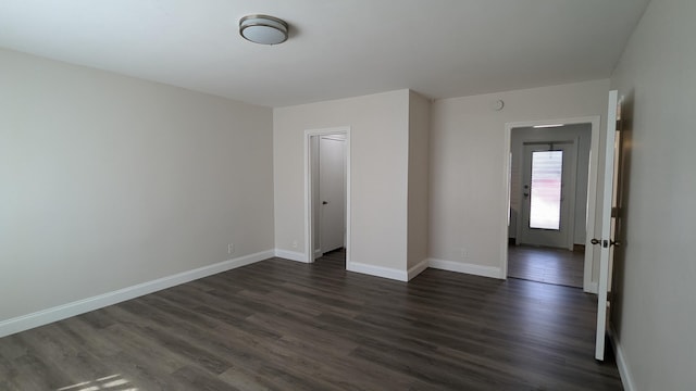 unfurnished room with dark hardwood / wood-style flooring