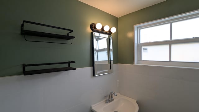 bathroom featuring tile walls and sink