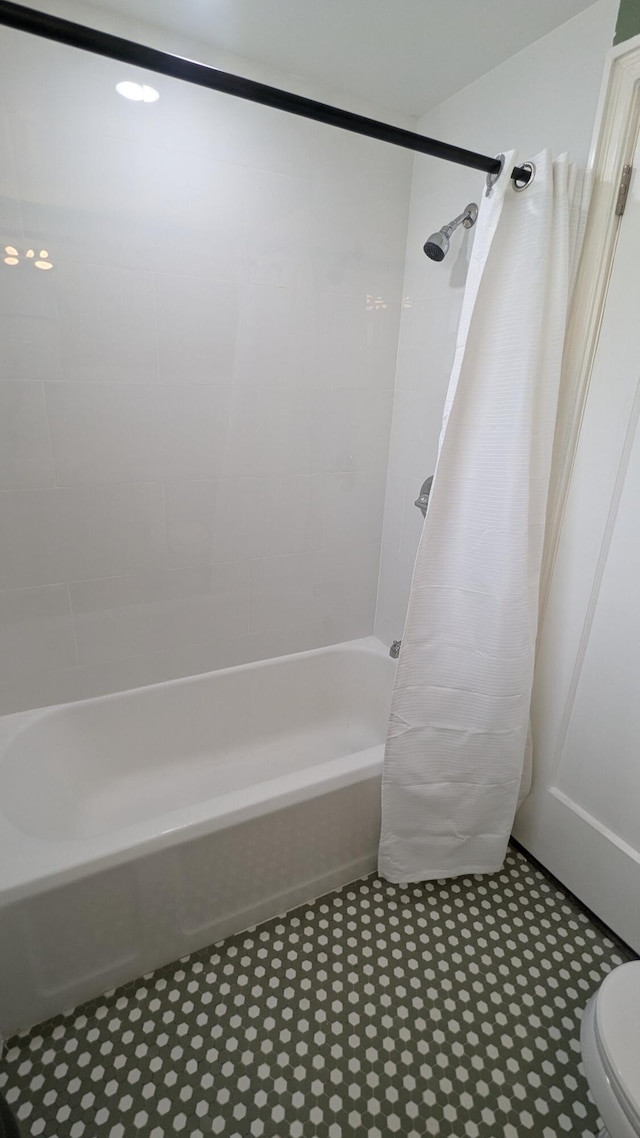 bathroom with shower / bath combination with curtain and toilet