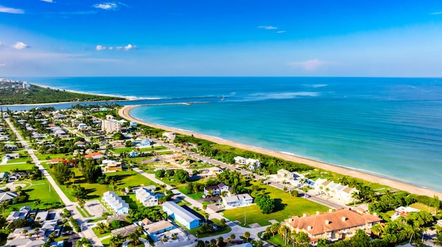 drone / aerial view featuring a water view and a beach view