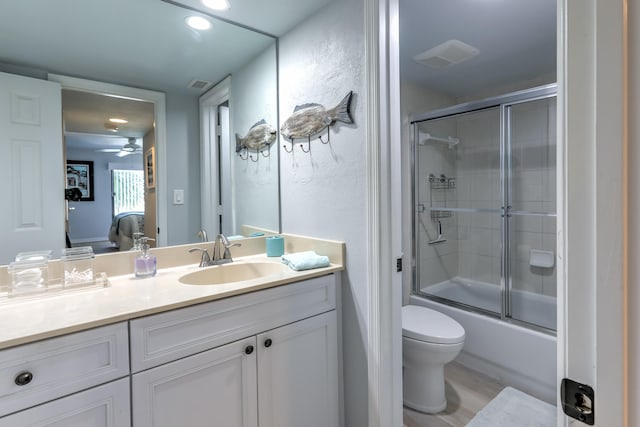 full bathroom with ceiling fan, vanity, wood-type flooring, toilet, and shower / bath combination with glass door